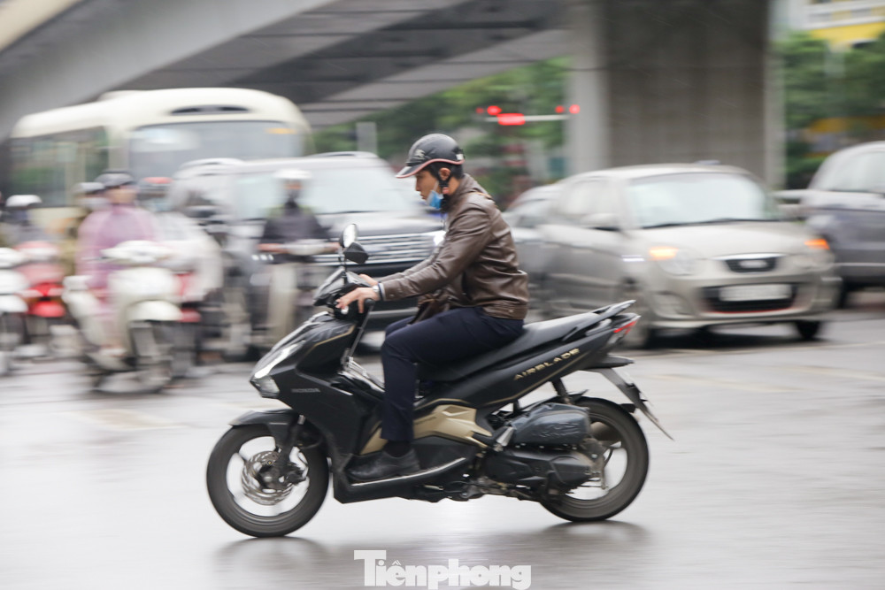 Tại ngã tư phố Cửa Nam, lượng người đổ về trung tâm Thành phố Hà Nội làm việc cũng khá đông. Người Hà Nội hối hả đội mưa đi làm tuần thứ hai 'cách ly toàn xã hội' ảnh 6