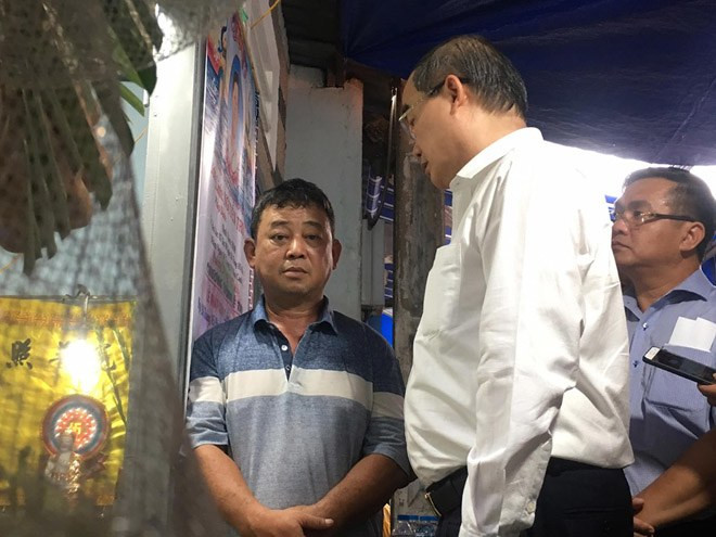 Bố của K. (ngoài cùng bên trái) vẫn chưa hết bàng hoàng trước sự ra đi của con trai. Toàn cảnh vụ cây phượng bật gốc đè vào người học sinh gây thương vong tại trường Bạch Đằng ảnh 9