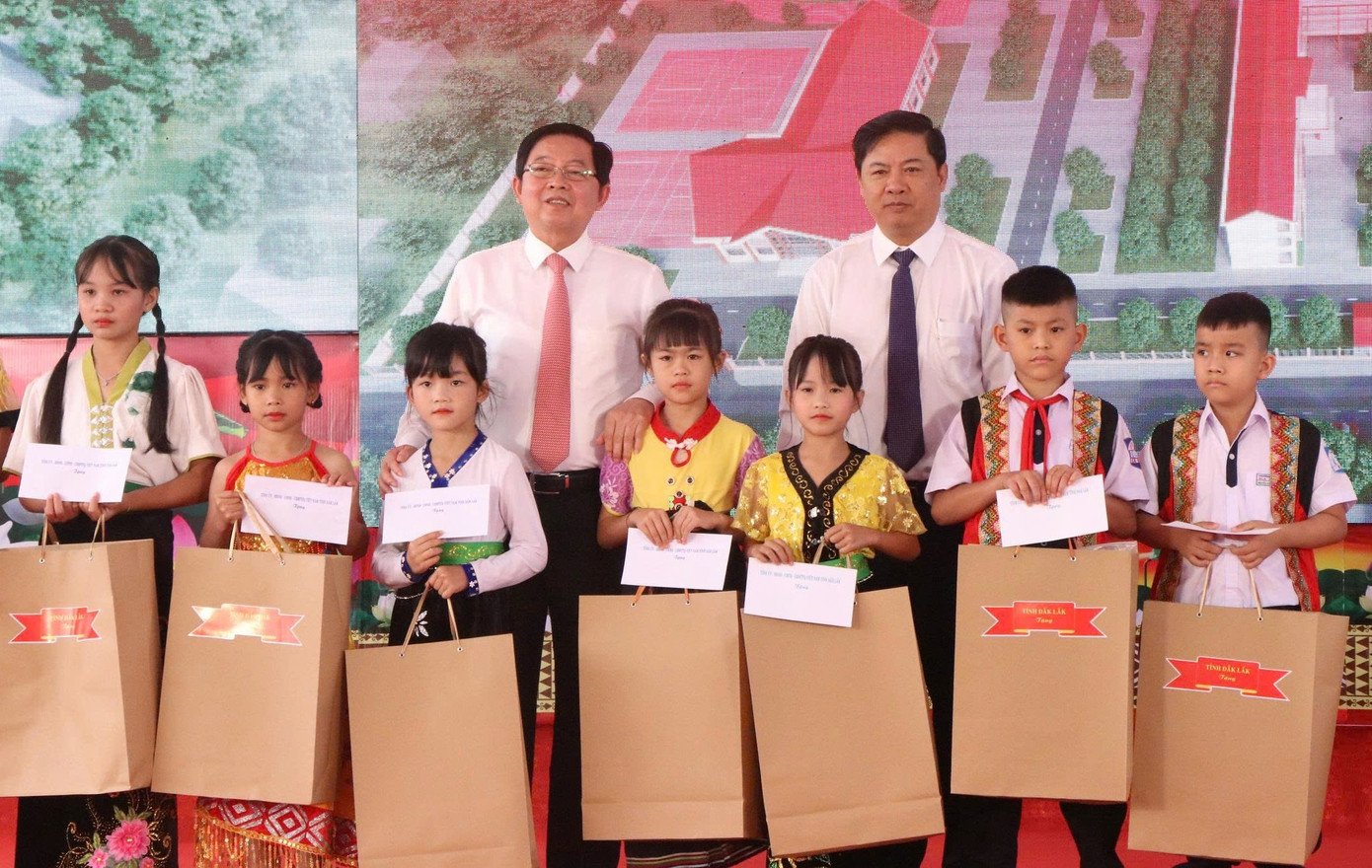 Phó Thủ tướng Chính phủ Hồ Quốc Dũng (bìa trái), cùng Bí thư Tỉnh ủy Đắk Lắk Lương Nguyễn Minh Triết, tặng quà cho các em học sinh.