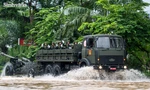 Người dân lội nước cổ vũ dàn xe khí tài quân sự vượt đường ngập 