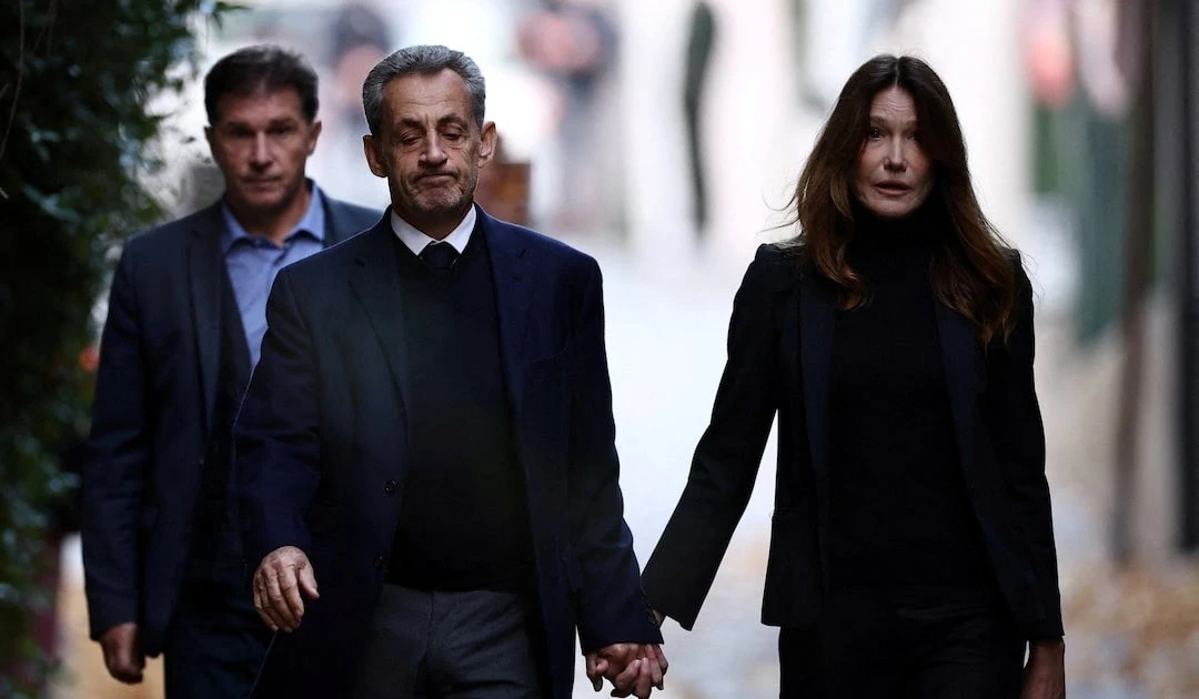 Cựu tổng thống Pháp nắm tay vợ trên đường đến nhà tù