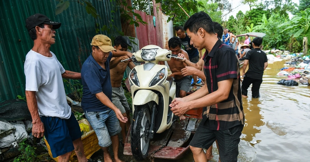 Nước sông Hồng tại Hà Nội dâng cao, người dân thuê thuyền đưa xe máy vào bờ