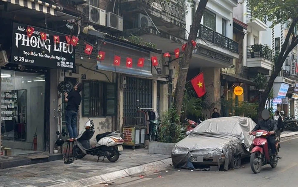 Cẩu, kéo chiếc ô tô phủ bạt, bị 'bỏ quên' nhiều năm trên phố Bát Sứ