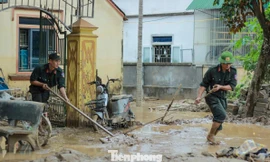Cảnh sát cơ động lội bùn, giúp dân dọn dẹp sau lũ