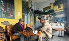 Nhà văn Y Ban (trái) tại quán cà phê ven sông Hồng