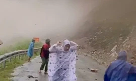 Đất đá từ trên núi rơi xuống khi đoàn cán bộ đi kiểm tra sạt lở