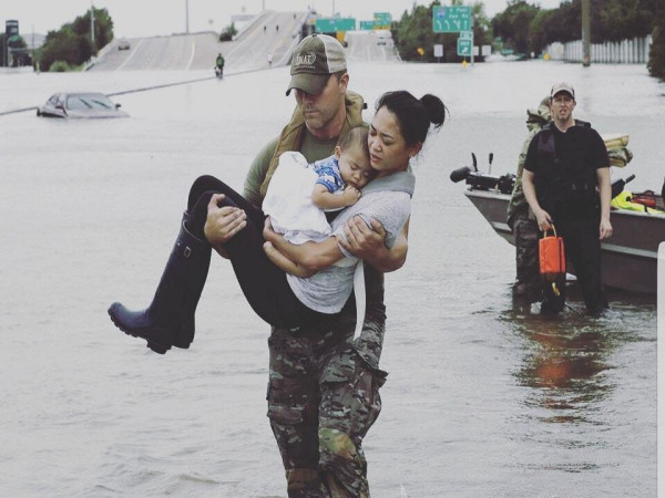 Hình ảnh hai mẹ con người châu Á được cứu khỏi ngôi nhà bị lũ cuốn gây xúc động mạnh