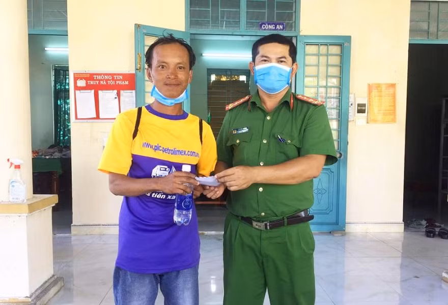 Công an phường Phổ Vinh và trạm CSGT Đức Phổ hỗ trợ tiền cho anh Thắng về quê. Ảnh (CA)