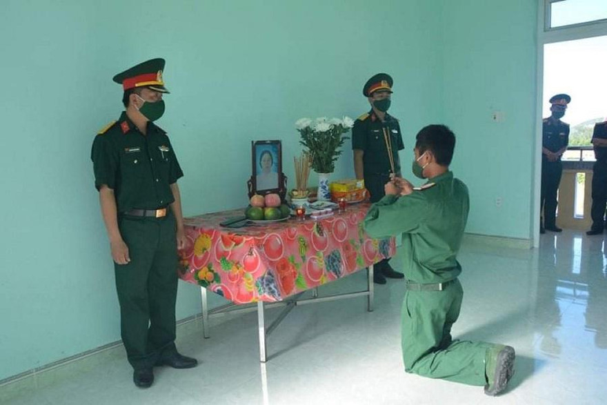 Binh nhì Nguyễn Huy Hoàng vọng bái mẹ trước bàn thờ được lập trong đơn vị. (Ảnh: B.N)