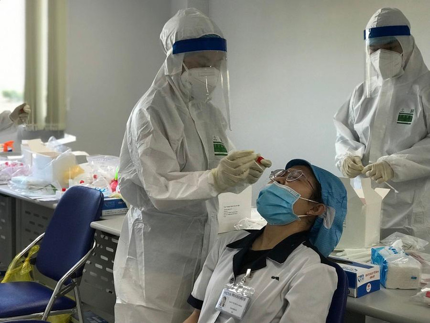 Tiến hành lấy mẫu xét nghiệm cho công nhân Công ty Hoya Lens Việt Nam, chi nhánh Quảng Ngãi. Ảnh: TP