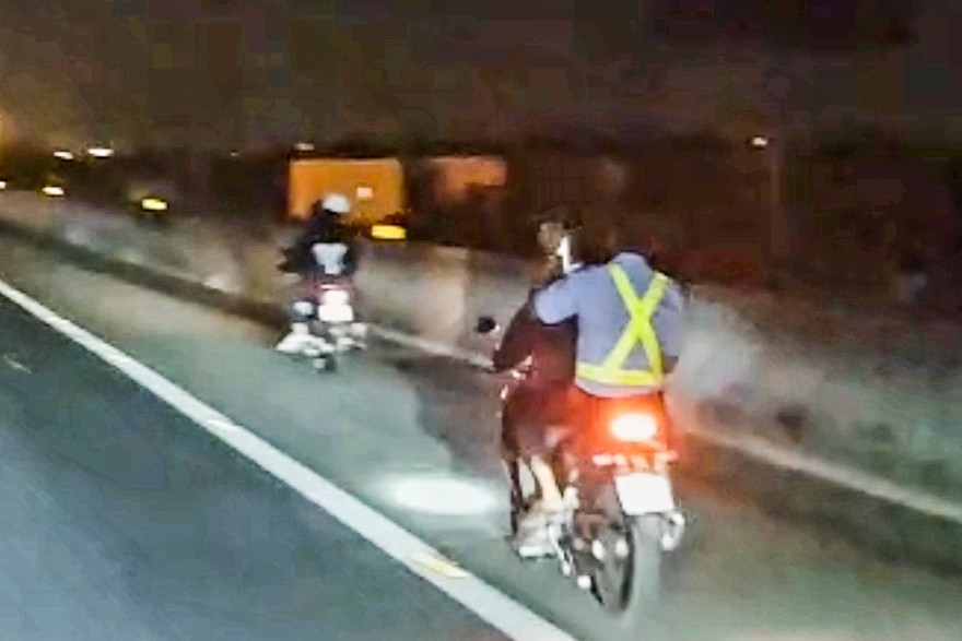 Hai xe máy chạy tốc độ cao trong làn dừng khẩn cấp trên cao tốc. Ảnh: Đ.T.