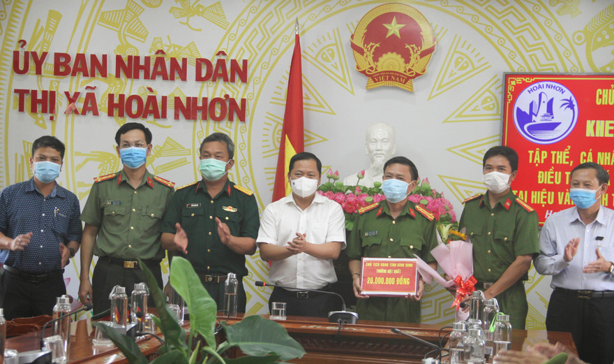 Chủ tịch UBND tỉnh Bình Định Nguyễn Phi Long khen thưởng cho tập thể, cá nhân có thành tích xuất sắc điều tra, phá vụ án trộm cắp tài sản tại hiệu vàng Anh Trung. Ảnh: Trương Định