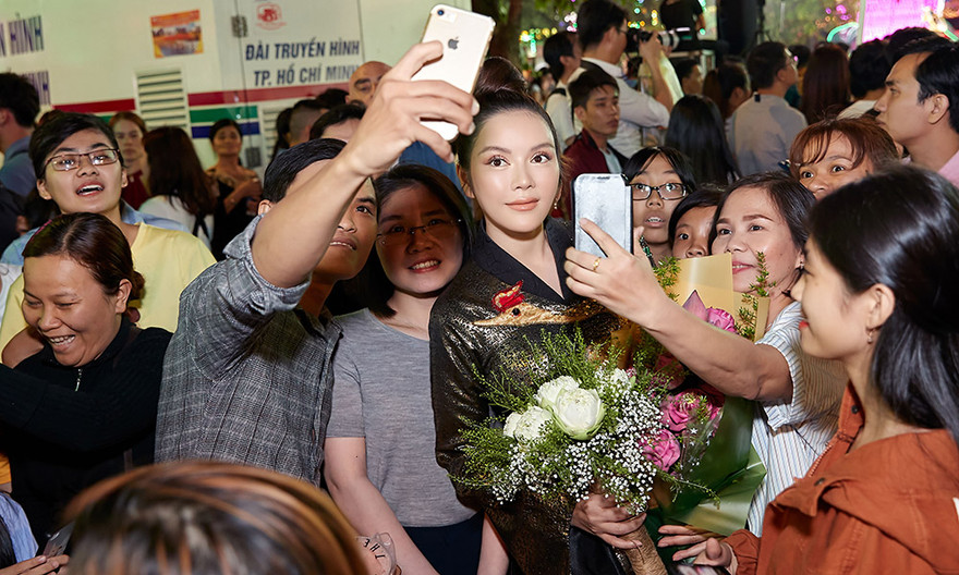 Lý Nhã Kỳ mặc áo dài dát vàng nổi bật ở phố đi bộ Nguyễn Huệ