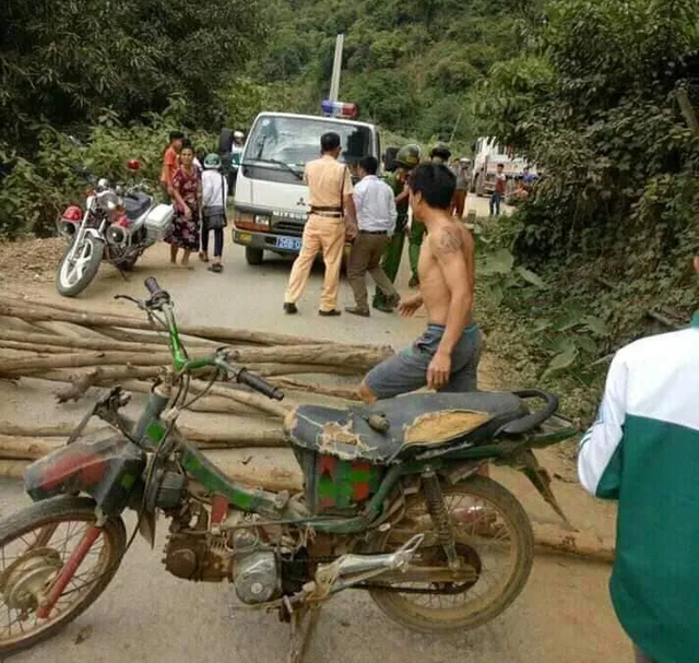 Hình ảnh người dân mang cả xe máy và cây củi ra chặn xe CSGT để "đòi lại" phương tiện vi phạm.