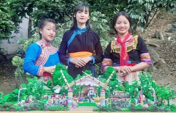 Ba học sinh bên mô hình “Sân chơi tái chế Happy garden”. Ảnh: NTCC