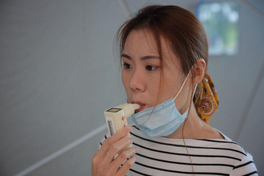 Người dùng chỉ mất 10 giây để thở vào máy và chưa đầy 2 phút sau có kết quả COVID-19. Ảnh: Straits Times
