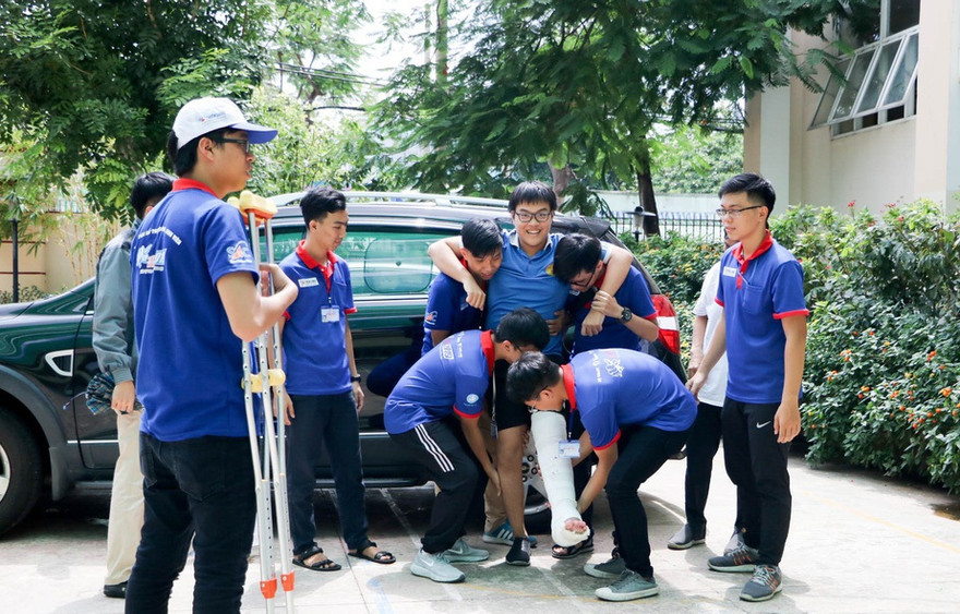 Thí sinh Nguyễn Hoàng Quốc Bảo, THPT Nguyễn Hiền (Q.11, TP.HCM), được các sinh viên tình nguyện đưa lên phòng thi. Ảnh: Trọng Nhân