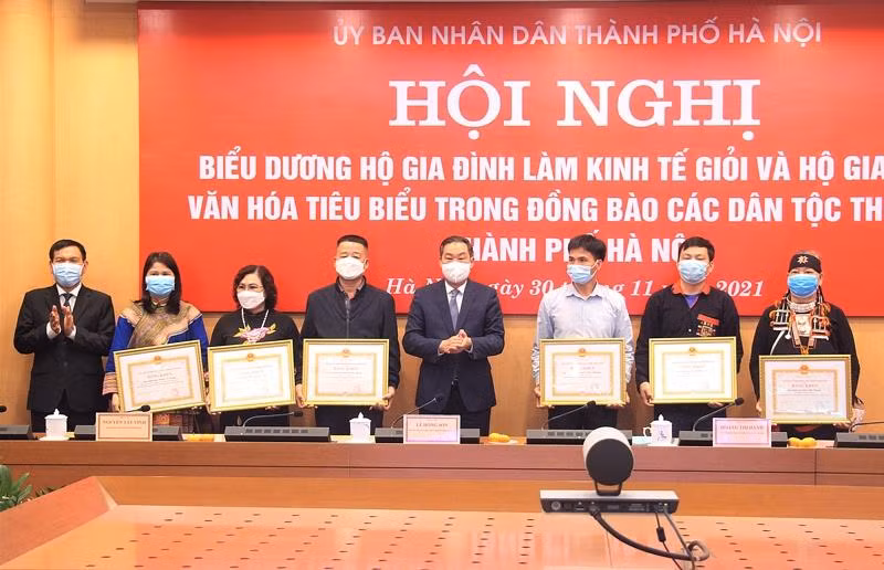 Ông Lê Hồng Sơn, Phó Chủ tịch Thường trực UBND TP. Hà Nội tặng Bằng khen của Chủ tịch UBND Thành phố cho các hộ gia đình tiêu biểu. Ảnh: TTXVN