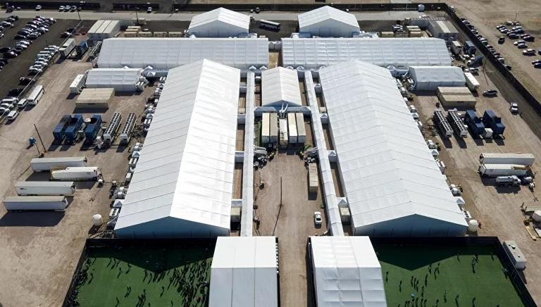 Những người di cư bị bắt vàđược nhìn thấy bên ngoài một trung tâm giam giữ sau khi cố gắng xâm nhập vào Mỹ, ở Donna, Texas.