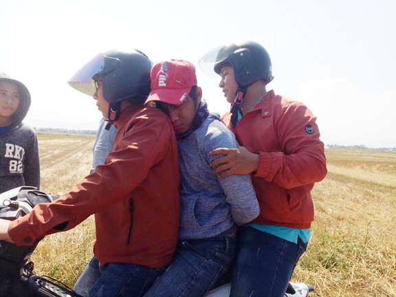 Công an huyện Phú Hòa áp giải Hãn (ngồi giữa) về trụ sở UBND xã Hòa Thắng - ảnh Văn Tài 