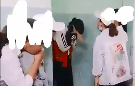 Nữ sinh Y. ôm mặt sau khi bị đánh hội đồng. Ảnh cắt từ clip