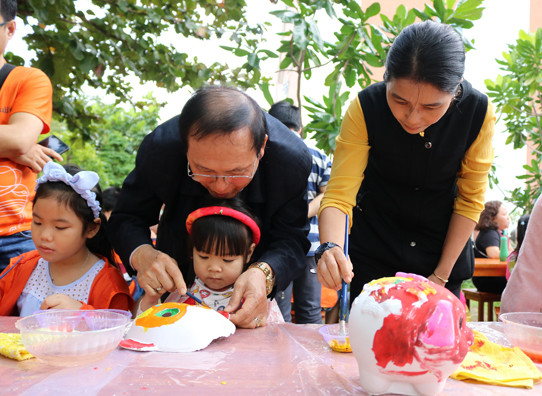 Cha mẹ, ông bà cùng con cháu tô heo đất tại phiên chợ Tết - ảnh Bích Ngọc 