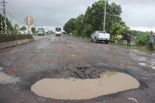Nhiều đoạn bong tróc chưa kịp “vá”, mặt đường đã xuất hiện thêm các ổ voi, ổ gà khiến người dân bất an. Ảnh: Tr. Định