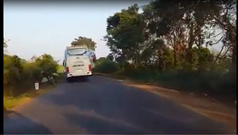 Chiếc xe khách lấn hết phần đường khiến xe máy phải lao lên lề, tông vào biển báo giao thông. Ảnh cắt từ clip