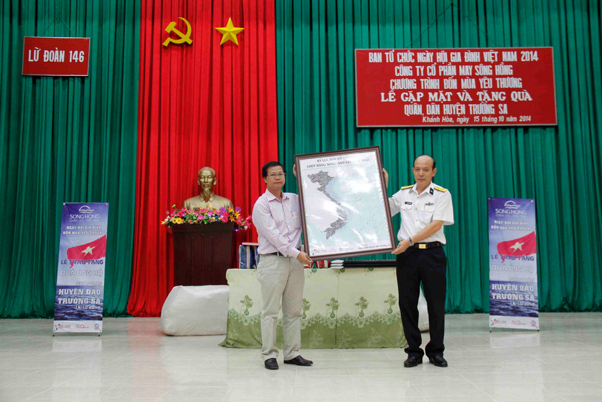 Ông Dương Văn Quynh - giám đốc Trung tâm triển lãm VHNT Việt Nam trao tặng bản sao thu nhỏ tấm bản đồ kỷ lục cho ông Nguyễn Văn Thắng- chính ủy lữ đoàn 146, vùng 4 hải quân.