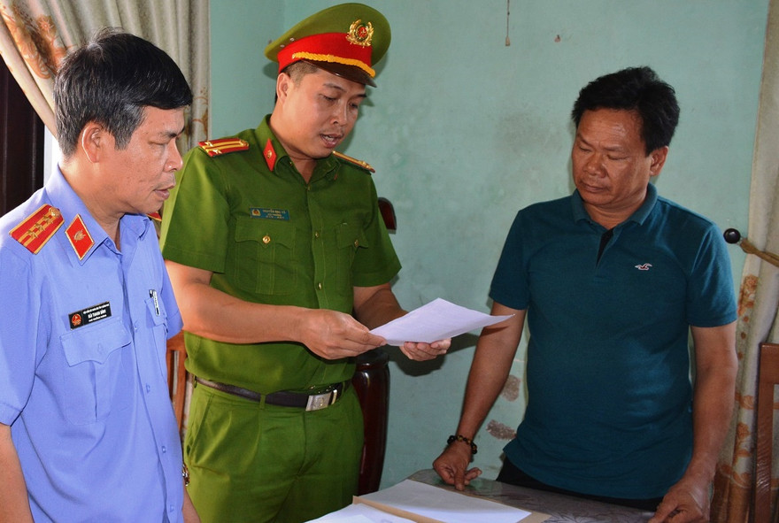 Cơ quan chức năng tống đạt quyết định đối với Lê Tự Trung. Ảnh CTV