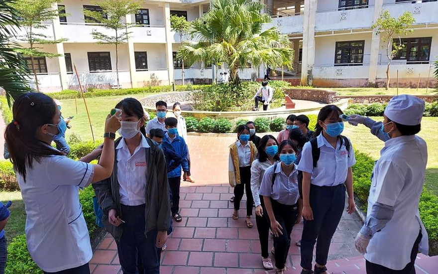 Các thí sinh dự thi Tốt nghiệp THPT xếp hàng đo thân nhiệt trước khi vào phòng làm thủ tục. ảnh H. Văn