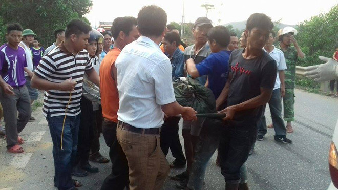 Người thân và lực lượng chức năng đưa hai anh em bị nạn ra khỏi hiện trường. 