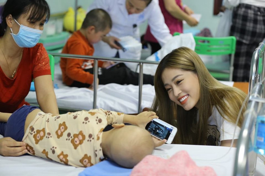 Á hậu 1 Hoa hậu Việt Nam 2018 Bùi Phương Nga vui đùa cùng một bệnh nhi đang điều trị tại Trung tâm Ung thư huyết học nhi khoa