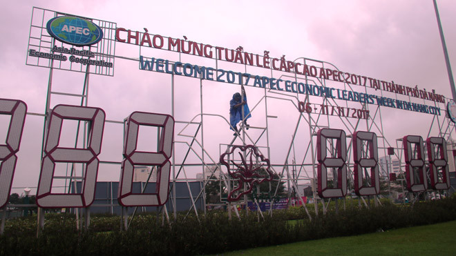 Một công nhân gia cố lại bảng đồng hồ đếm ngược chào mừng Tuần lễ Cấp cao APEC hư hỏng sau bão ngay giao lộ cầu Sông Hàn- Ngô Quyền – Phạm Văn Đồng. Ảnh Nguyễn Thành