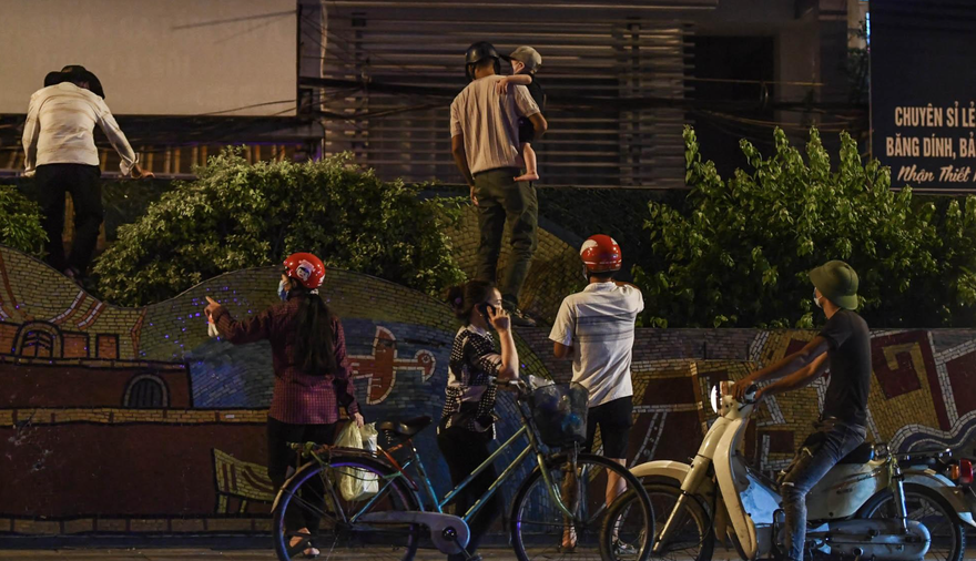 Người dân trèo qua dây thép gai để ra ngoài và vận chuyển hàng hóa tại phường Chương Dương. Ảnh: Dantri