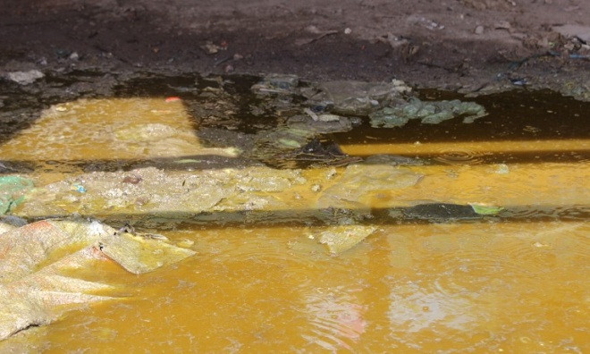 Hàng trăm lít hóa chất tràn xuống đường. Ảnh: Đông Sơn.