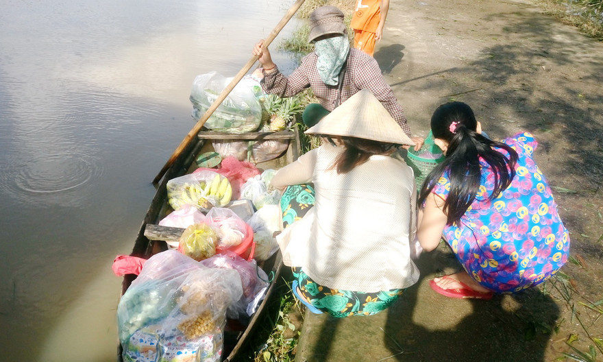 Tiếp tế thực phẩm cho các hộ dân mắc kẹt trong lũ bằng ghe.