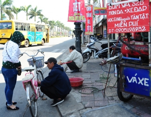 Anh Trần Viết Hùng đang bơm xe cho cháu Trương Anh Thư trưa mùng bốn Tết.
