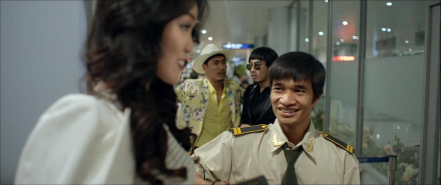 Hình ảnh của Lệ Rơi trong phim 'Sơn đẹp trai' với vai nhân viên an ninh ở sân bay.