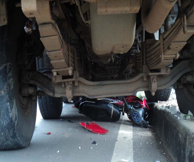 Xe máy lọt gầm xe tải