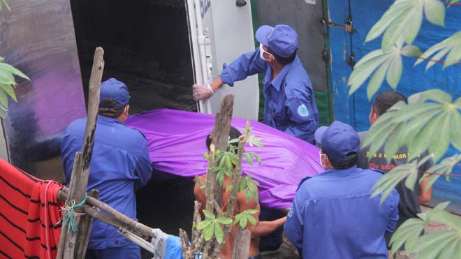 Lực lượng chức năng tiến hành đưa thi thể về nhà xác.