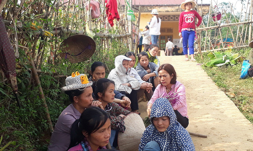 Phụ huynh ngồi chờ con trước cổng trường để đón con về theo ca học. Ảnh: Hoàng Lam.