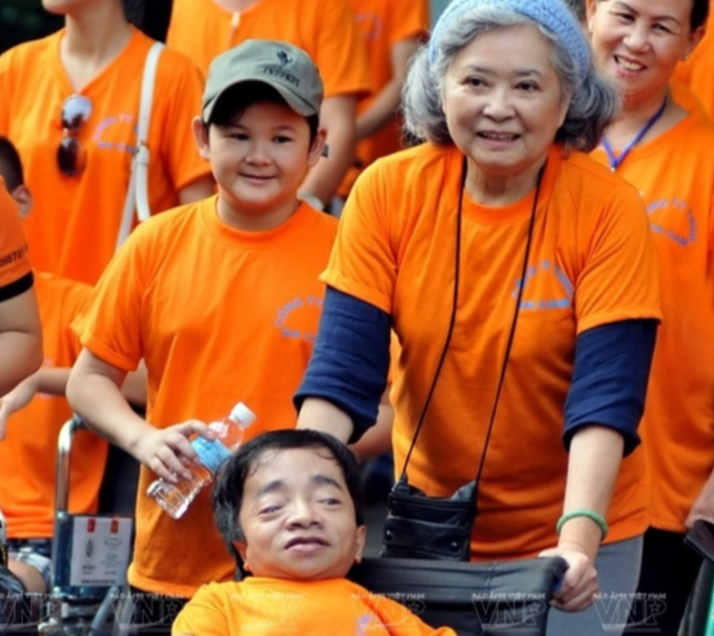 Bà Trần Tố Nga (đẩy xe) trong một lần đi bộ đồng hành cùng các nạn nhân chất độc da cam ở TP. HCM. (Ảnh: Thời đại)