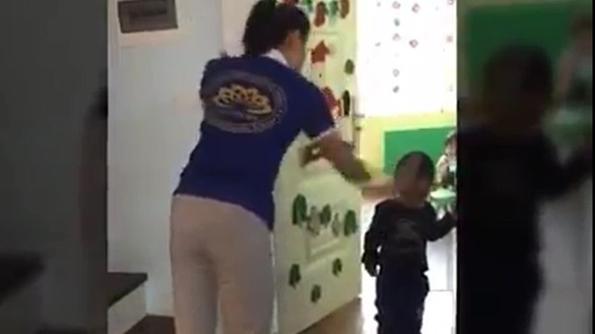 Cô giáo cầm dép đánh vào đầu học sinh. Ảnh cắt từ clip