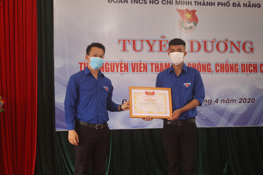Anh Nguyễn Mạnh Dũng, Bí thư Thành Đoàn Đà Nẵng trao bằng khen cho các TNV tích cực tham gia hỗ trợ các chốt kiểm soát dịch. Ảnh: Giang Thanh
