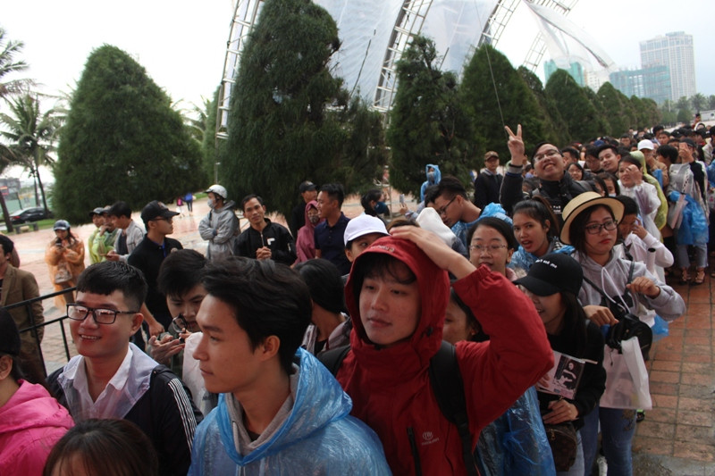 Hàng trăm người hâm mộ Đà thành "đội" mưa, đợi ca sĩ "họa mi tóc nâu" từ hơn 15g. Ảnh: Giang Thanh