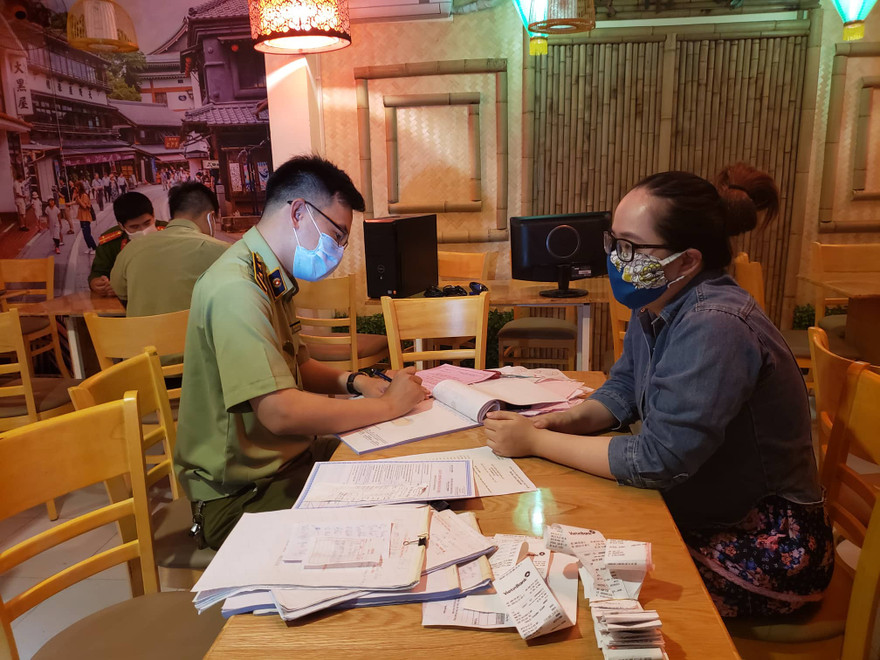 Lực lượng quản lý thị trường làm việc với chủ cửa hàng Michi Sushi & Mì cay vì vẫn bán đồ ăn cho khách bất chấp lệnh cấm