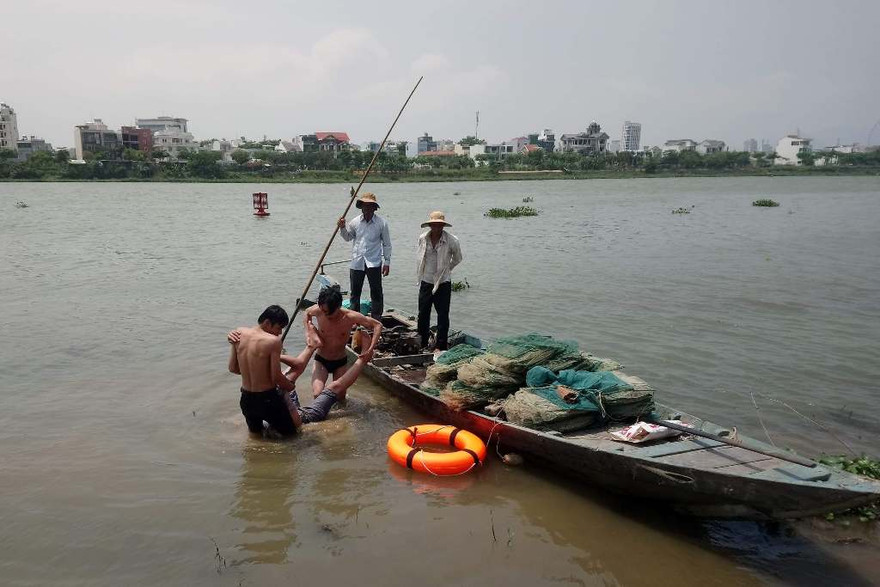Hai bảo vệ đưa nạn nhân vào bờ sau khi ứng cứu