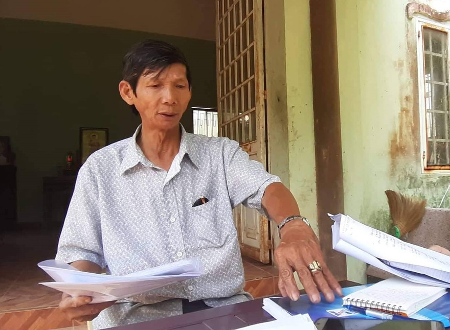 Ông Nguyễn Văn Côi và hồ sơ giấy tờ liên quan đến việc khiếu nại của gia đình. Ảnh: Nguyễn Thành