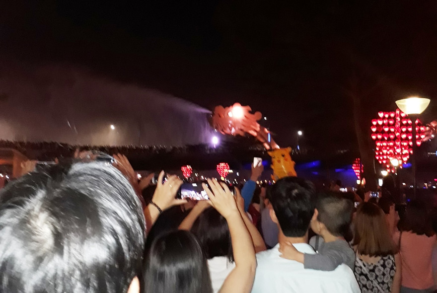 Du khách xem cầu Rồng phun nước, phun lửa. 